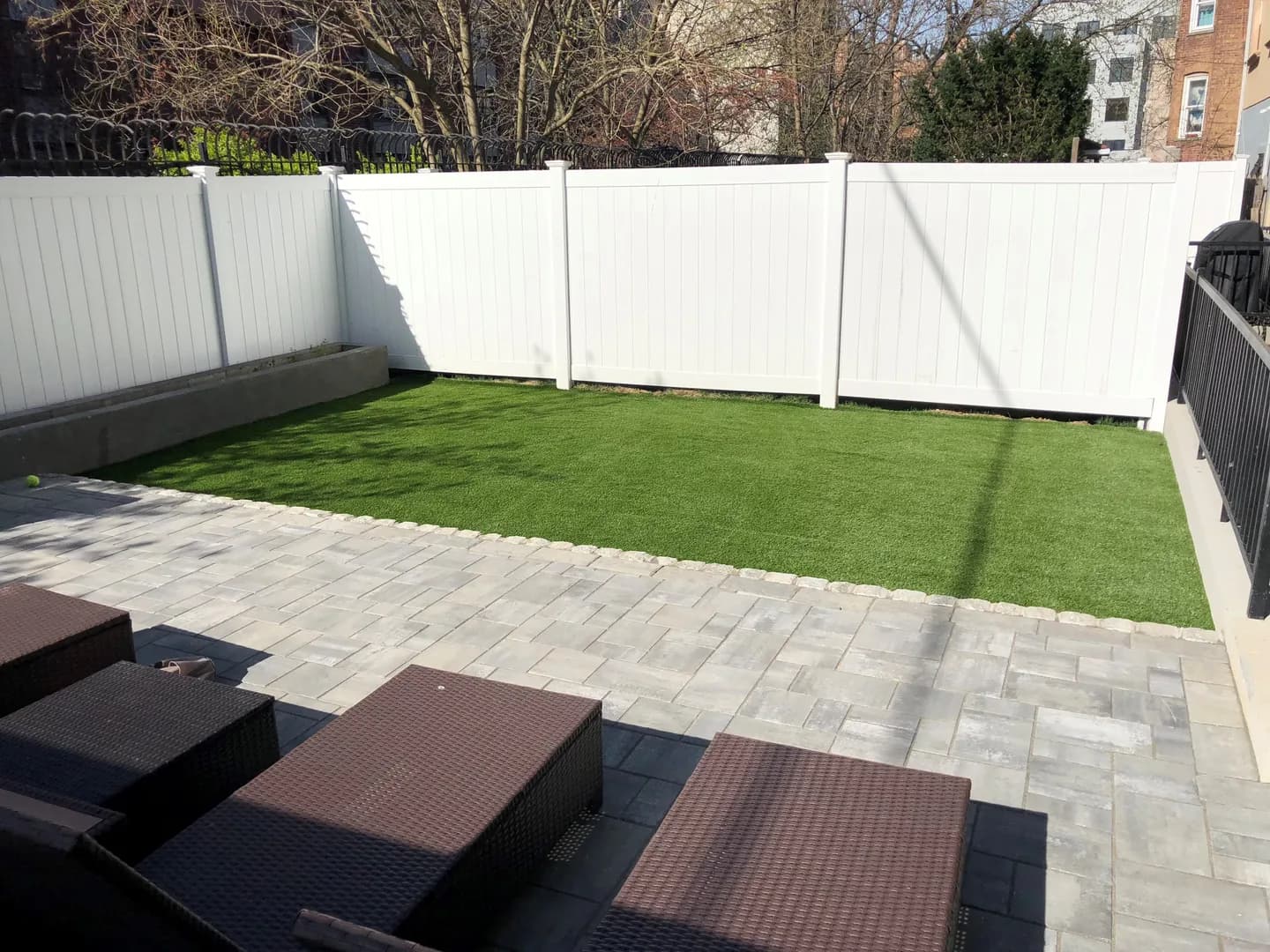 Residential artificial turf lawn with surrounding landscaping