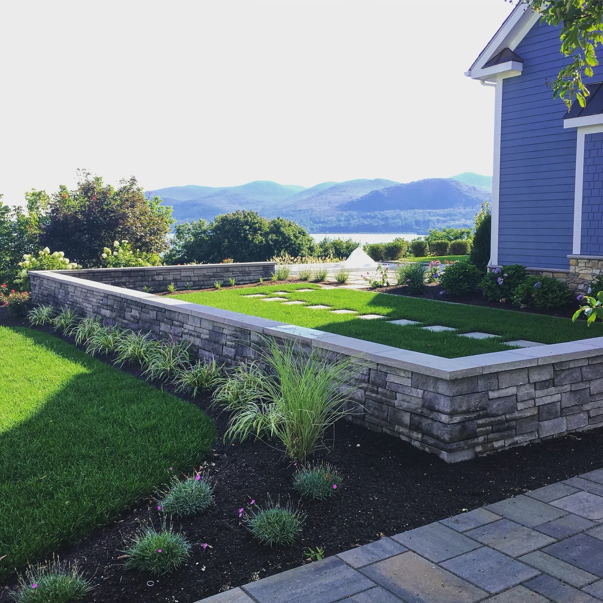 Stone patio with a tiered natural stone retaining wall