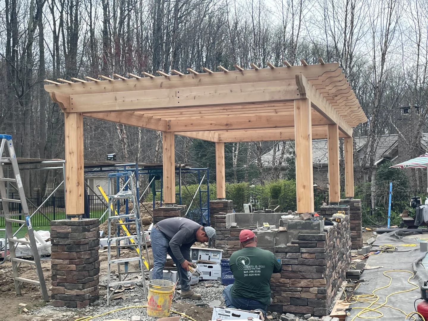 Outdoor kitchen under construction with a stone masonry base
