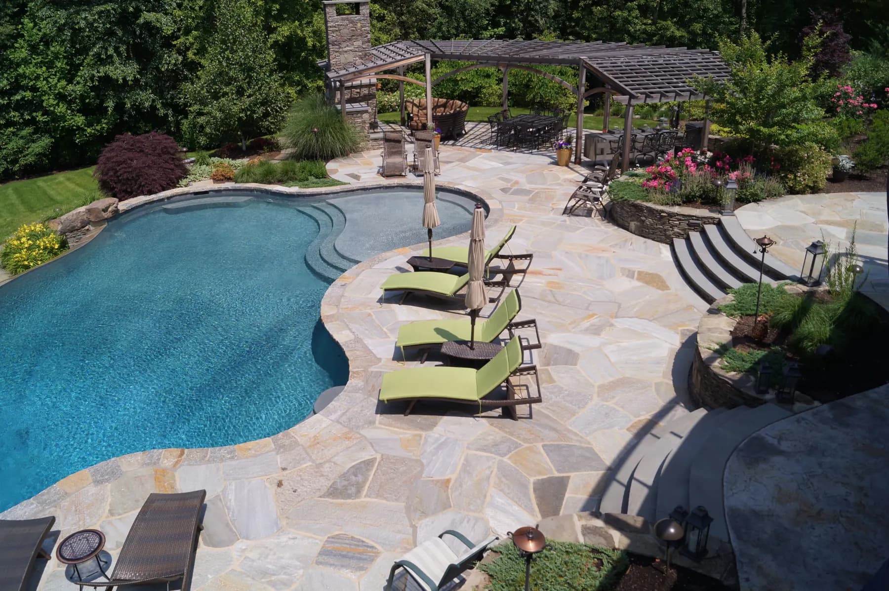Pool surrounded by stone patio at a residential property