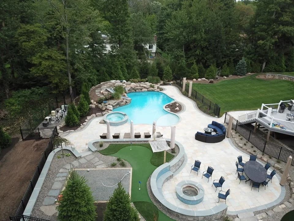 Residential swimming pool set into a landscaped backyard